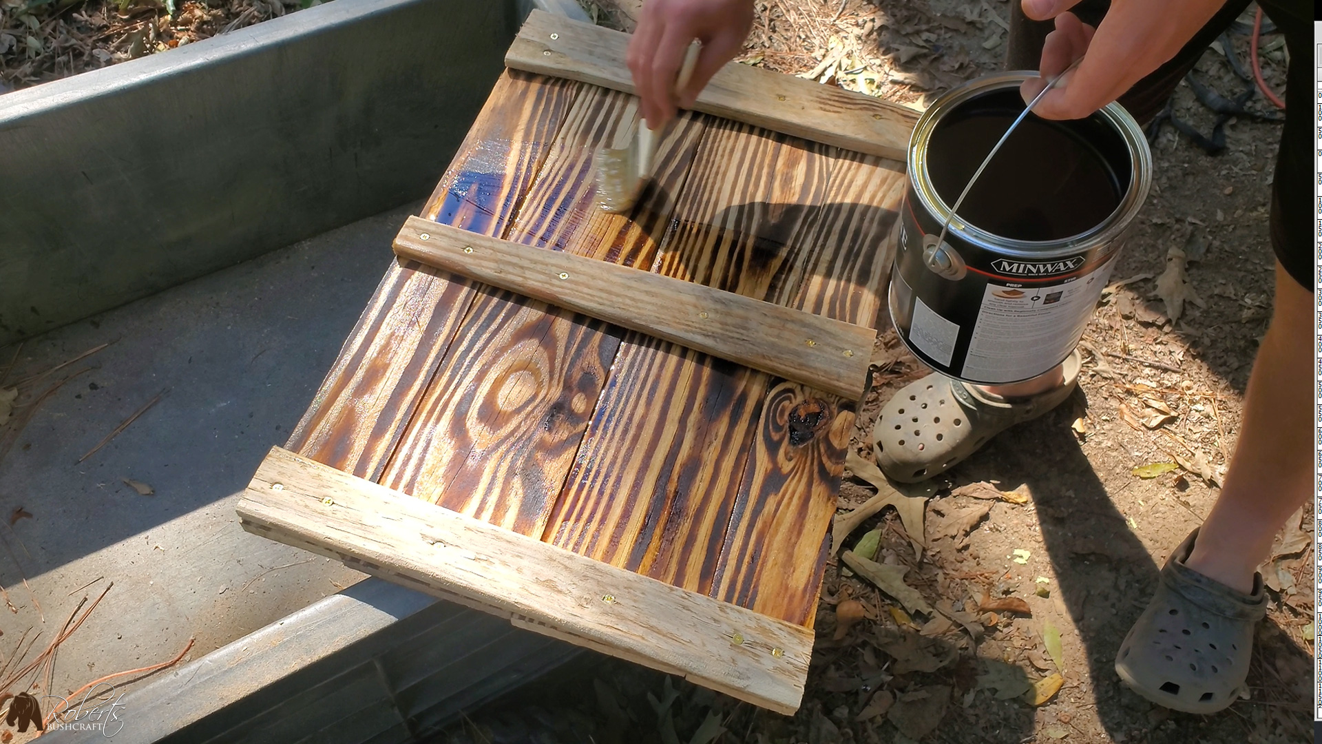 Brushing on a coat of polyurethane on the hand-made shutter